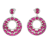 Elegant oval pink sapphire earrings in sterling silver, featuring a dazzling circular design with multiple gemstones.